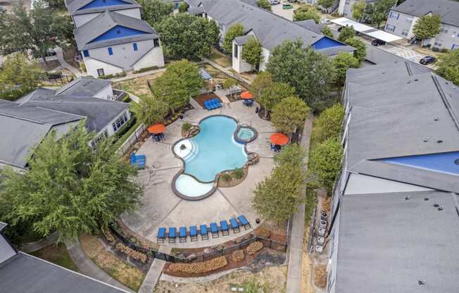 an aerial view of a pool in the backyard of a house