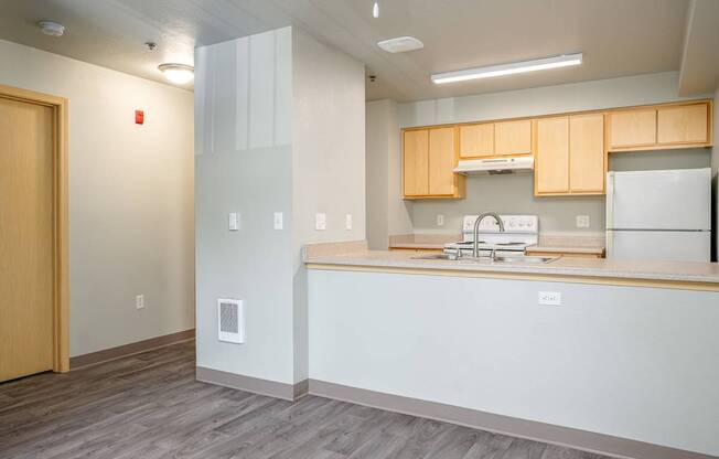 A kitchen with a sink, stove, and refrigerator.