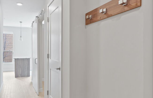 A long hallway with a wood panel on the wall.