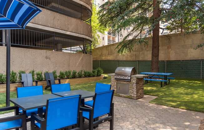 a patio with tables and chairs and a barbecue grill