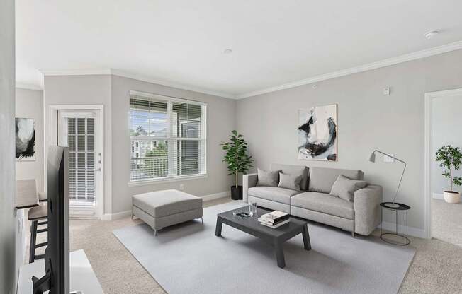 A living room with a grey couch, a white chair, and a coffee table.
