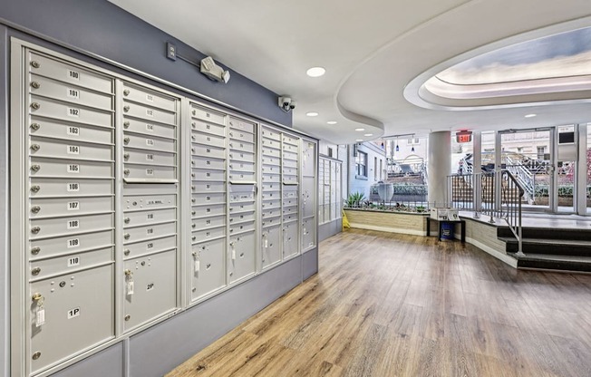 A long hallway with mailboxes on the wall and a staircase on the right.