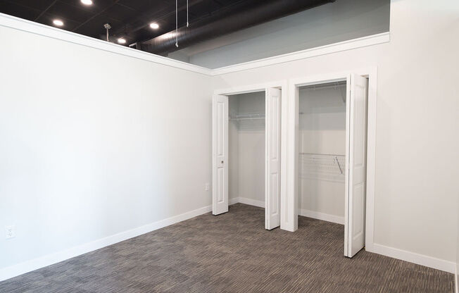 a room with white walls and a closet with doors