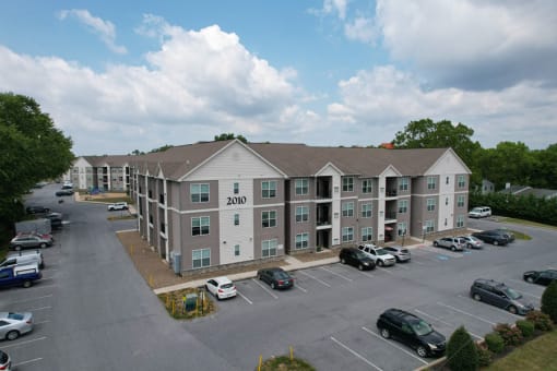 an aerial view of an apartment building with a parking lot