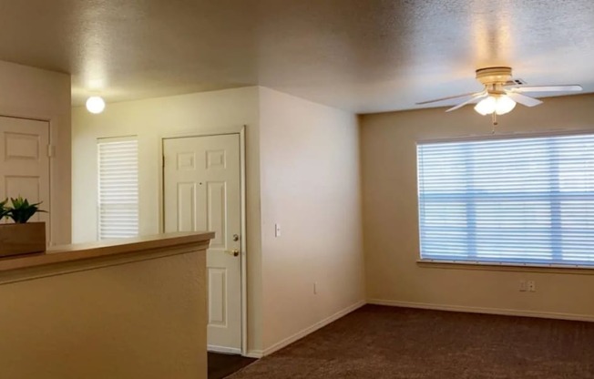a bedroom with a large window and a ceiling fan at EDGEWOOD AT GABLES Apartments, Oklahoma, 74127