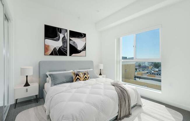A bedroom with a large bed and a painting on the wall.