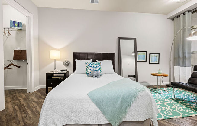 a bedroom with a bed and a mirror on the wall