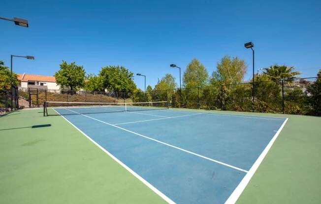 A tennis court with a blue surface and white lines.