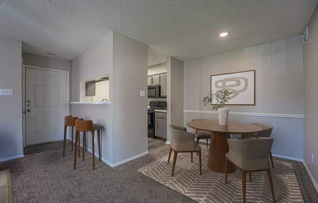 A dining room with a table and chairs.