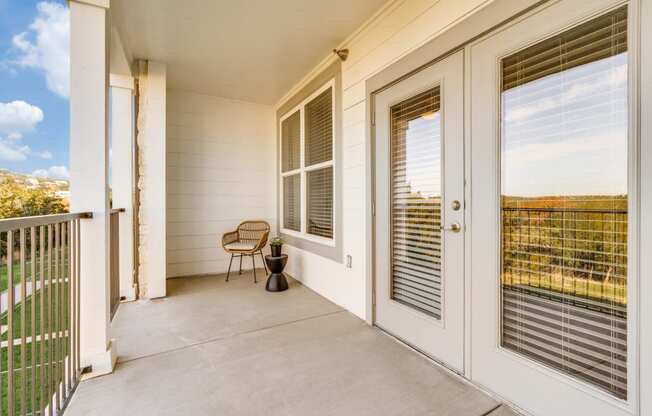 a porch with two doors and a chair on it