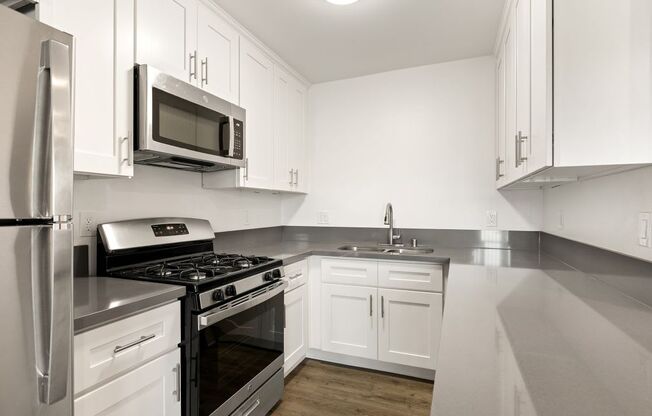 a kitchen with stainless steel appliances and white cabinets