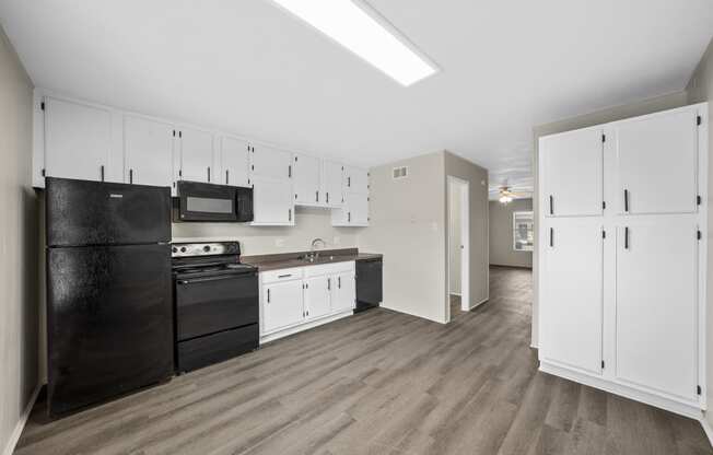 an empty kitchen with black appliances and white cabinets at Brookside Apartments, Hewitt, TX