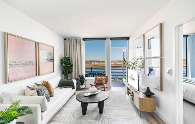 Open living with clean finishes, soft light, and direct access to a private balcony.