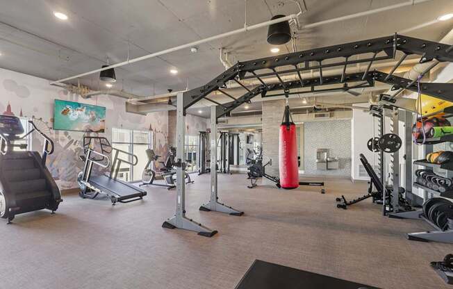 A gym with a variety of equipment including treadmills, weights, and exercise machines.