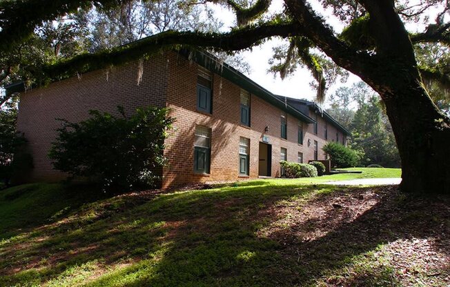 a large brick building with a tree in front of it