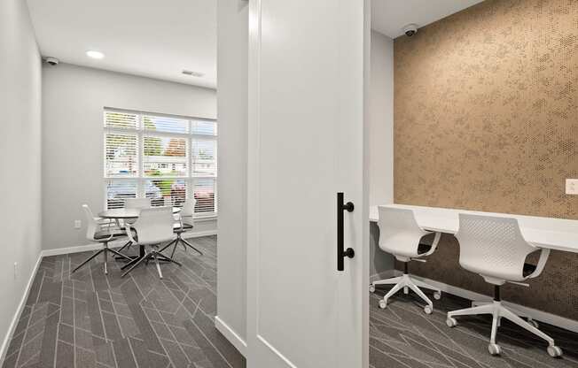 a conference room with white desks and chairs and a window