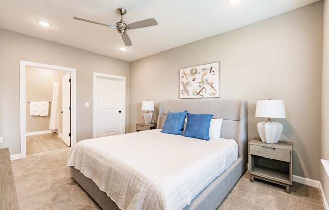 a bedroom with a bed, a night stand, and a bathroom