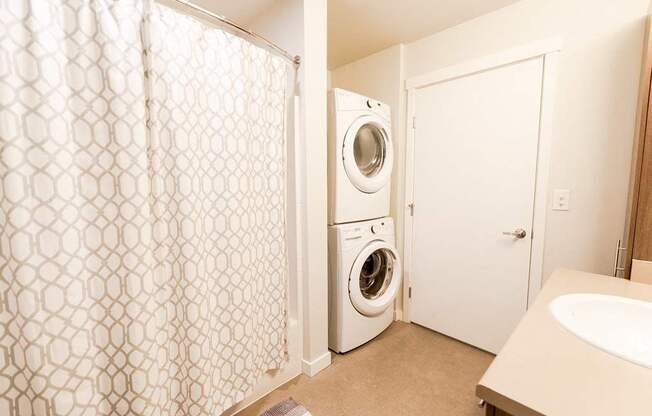 A white washing machine sits in a small laundry room. at The Platform, Kent, Washington
