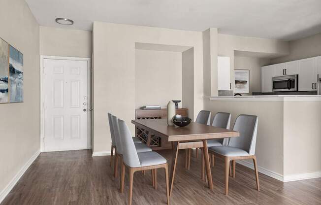 A dining room with a table and chairs.