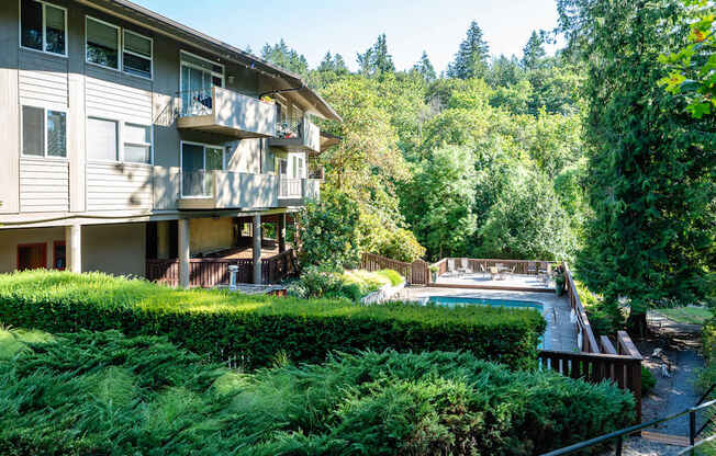 A building with a balcony is surrounded by greenery.