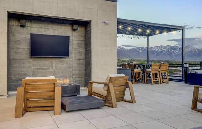 the patio has a fire pit and a tv on the wall