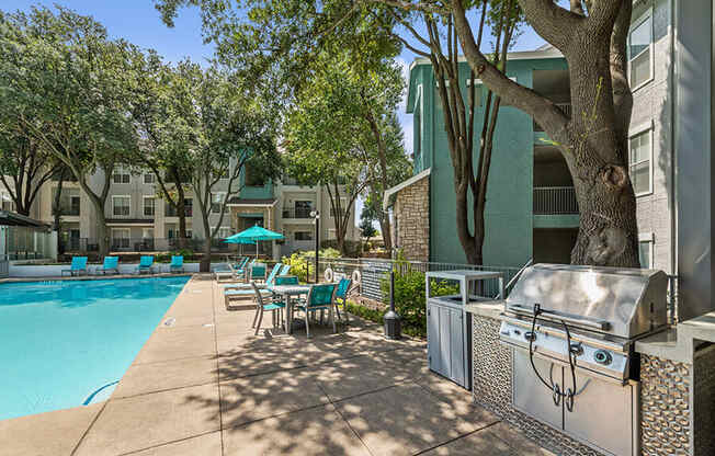 Community Swimming Pool with Pool Furniture at Essence Apartments in Dallas, TX.