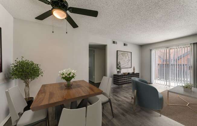 an open living room and dining room with a table and chairs and a ceiling fan