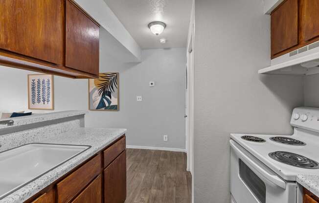 the kitchen of our studio apartment atrium with white appliances and wood cabinets