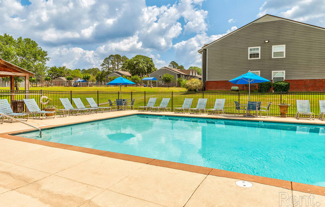 our resort style swimming pool is next to our house with lounge chairs