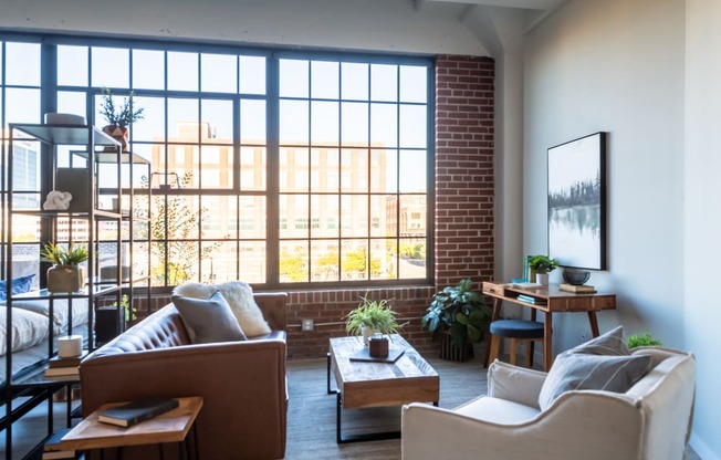 a living room filled with furniture and a large window at The 22 Apartments, St. Louis, 63103