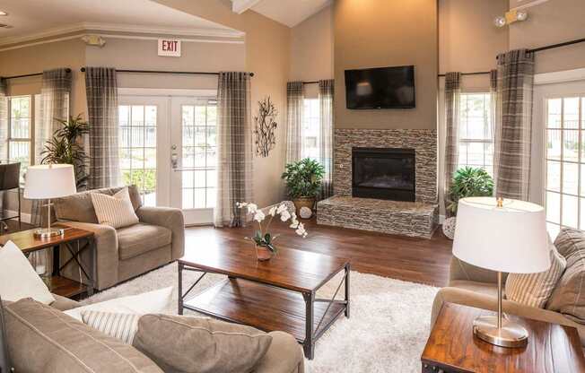 A living room with a fireplace and a flat screen TV mounted above it.