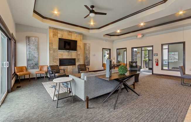 A living room with a stone fireplace and a grey sofa.