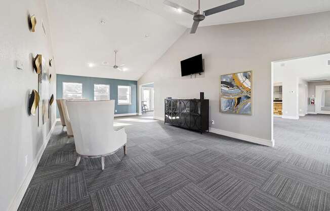 A living room with a grey carpet and a white chair.