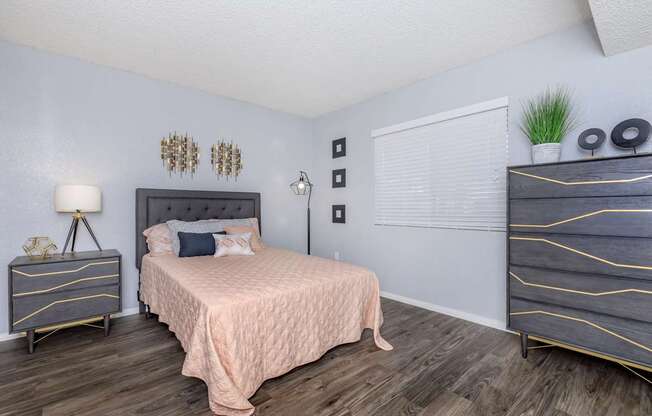 A bedroom with a bed, nightstand, and dresser.