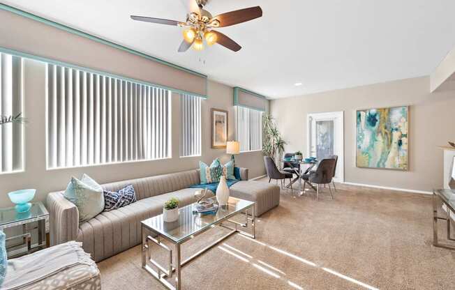 A living room with a couch, chairs, and a ceiling fan. at The Fairways by Picerne Apartments, Las Vegas, NV