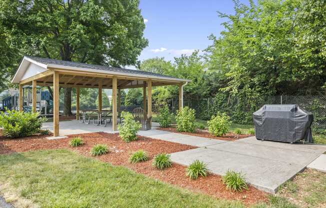 a covered patio with a covered pavilion in a yard with trees