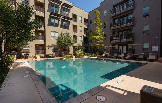 an apartment swimming pool in front of an apartment building