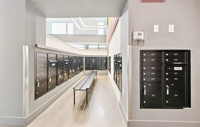 A long hallway with a bench and a row of lockers on the side.