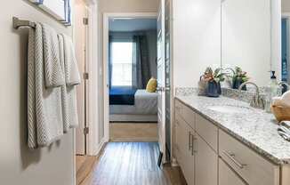 a bathroom with a sink and a door to a bedroom