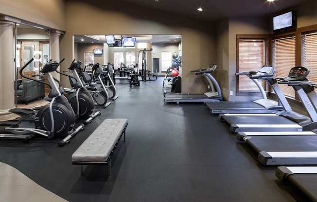 A gym with treadmills, elliptical machines, and other exercise equipment.