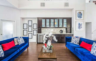 A living room with blue couches and a coffee table.