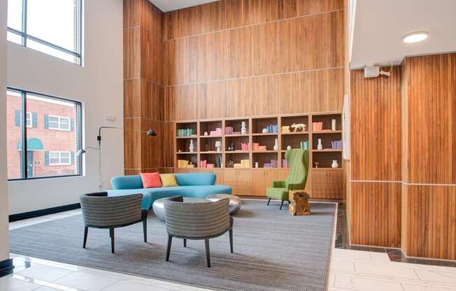 A room with a wooden bookshelf and a grey carpet.