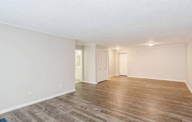 A room with wooden flooring and white walls.