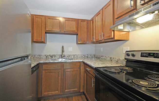 an empty kitchen with wood cabinets and black appliances