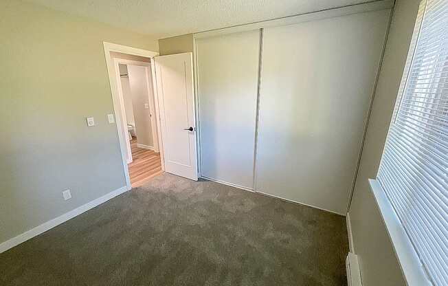 A room with a carpeted floor and a white door.