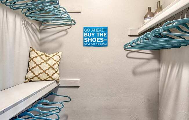 A white bench with a gold pillow and a wall with a sign that says