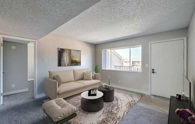A living room with a couch, a coffee table, and a painting on the wall.