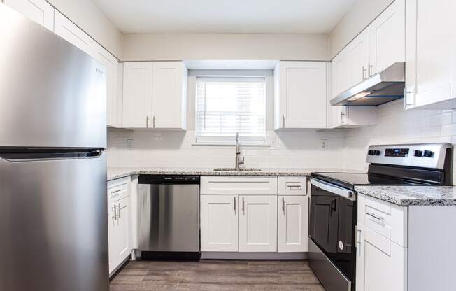 a kitchen with white cabinets and stainless steel appliances and window  at Barcelo at East Cobb, Marietta, GA