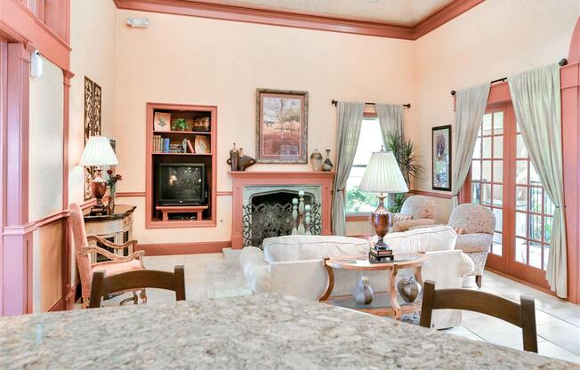 Room with countertop chairs and a sofa with lamps and fireplace