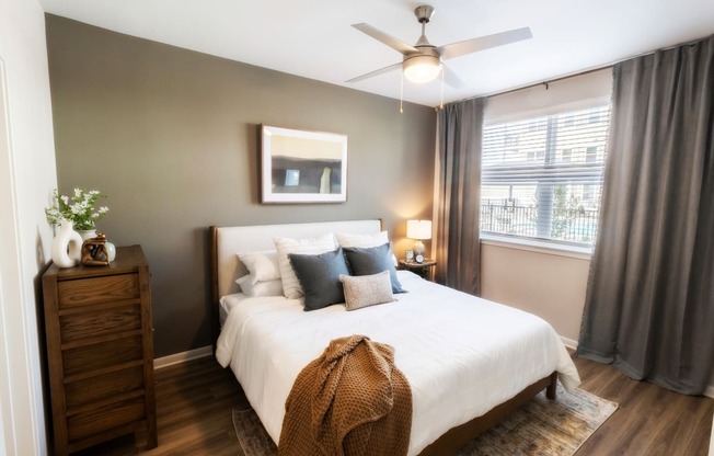 a bedroom with a large white bed and a ceiling fan